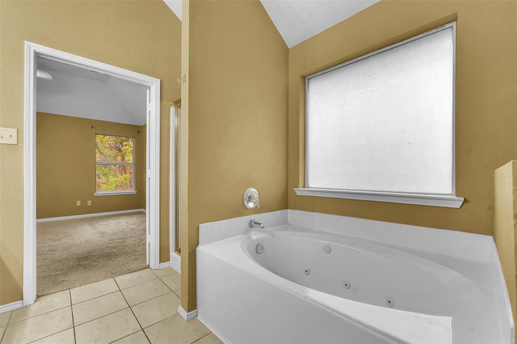4507 Stones River Road Grand Prairie, TX 75052 - Photo 25 of 28 a bathroom with a bathtub and shower