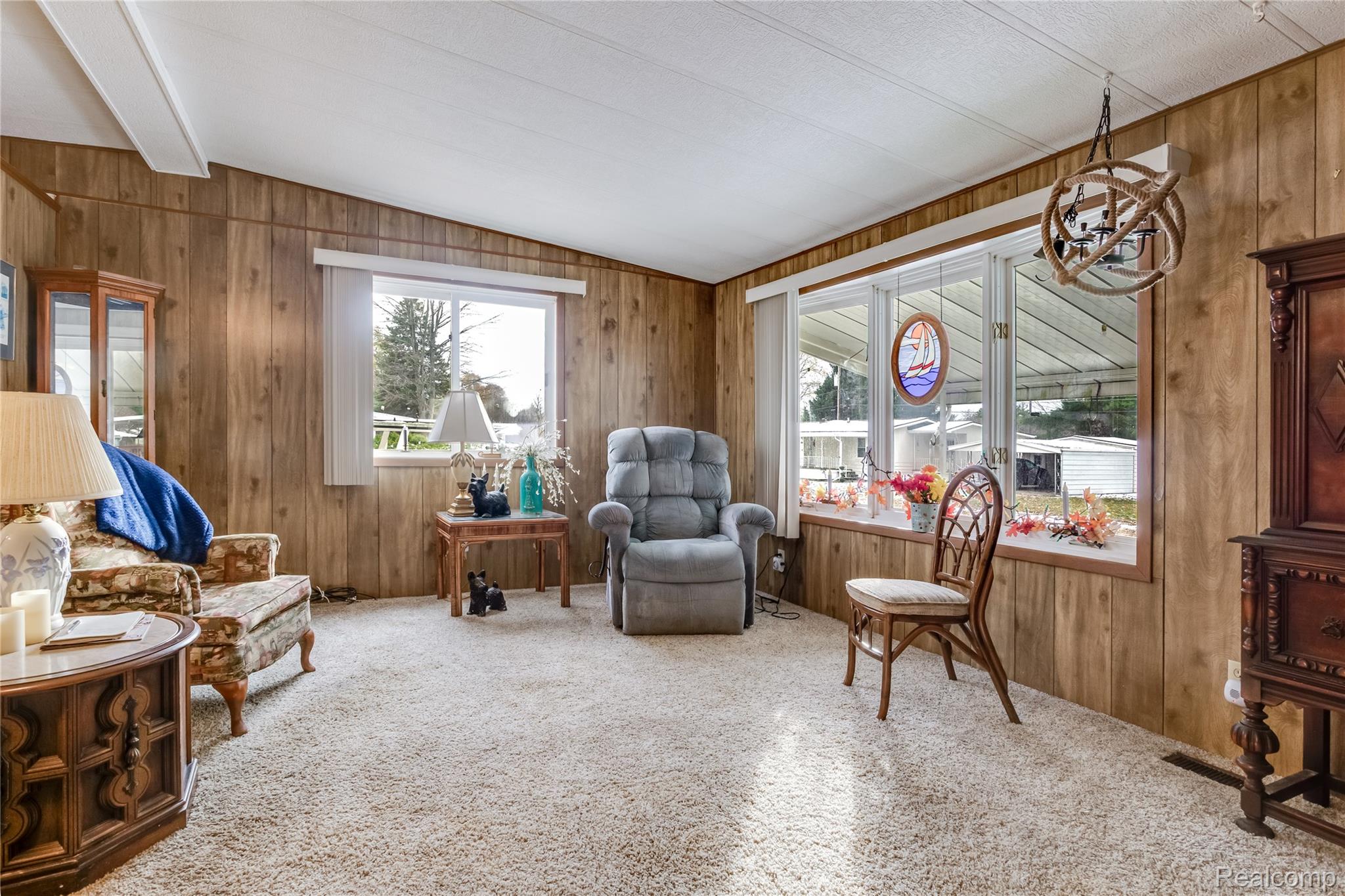 3333 Ravenswood Road Marysville, MI 48040 - Photo 10 of 25 Sitting room with carpet, wooden walls, a chandelier, and lofted ceiling with beams