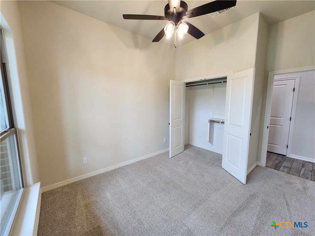 406 Talon Loop Salado, TX 76571 - Photo 13 of 31 an empty room with a ceiling fan and a walk in closet