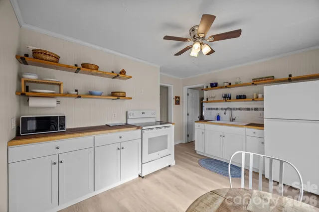 a kitchen with white cabinets and white appliances