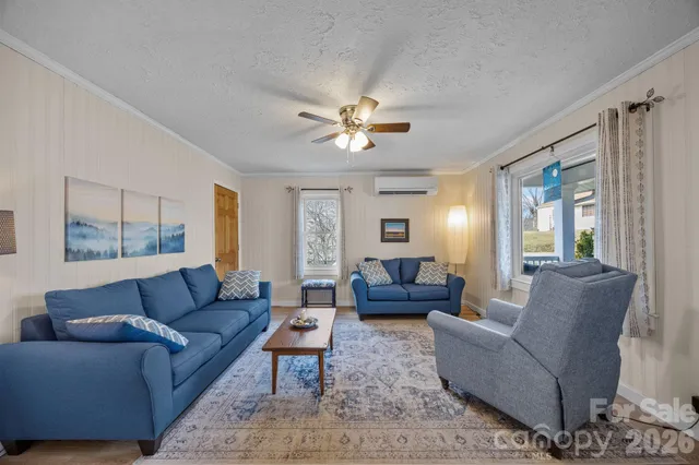 a living room with furniture ceiling fan and a window