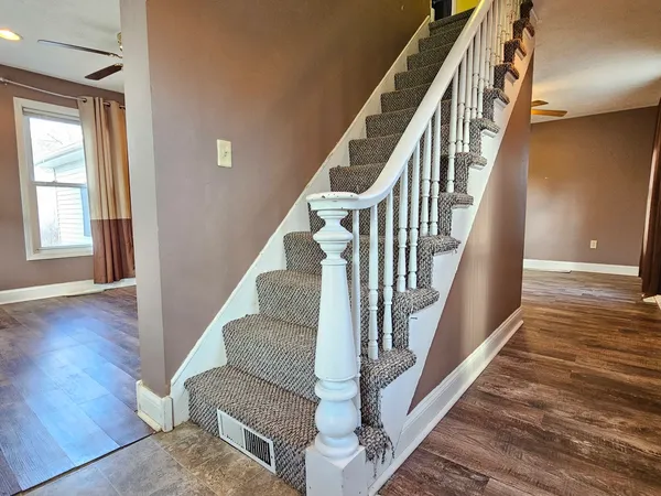 a view of staircase with wooden floor and a rug