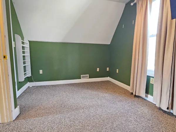 a view of a livingroom with an empty space and a window
