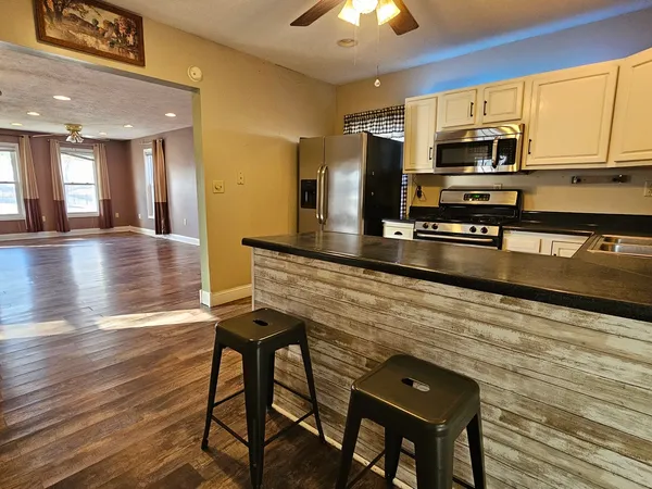 a kitchen with stainless steel appliances granite countertop a stove refrigerator sink and microwave