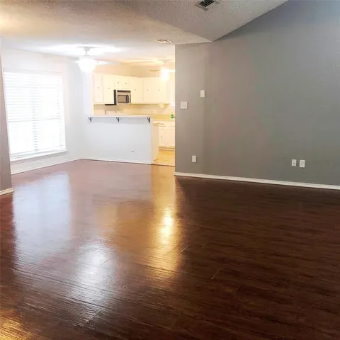 a view of a kitchen with wooden floor and a window