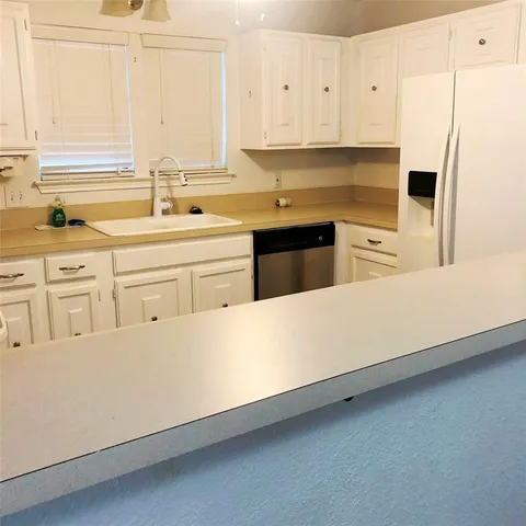 a kitchen with stainless steel appliances white cabinets and a refrigerator