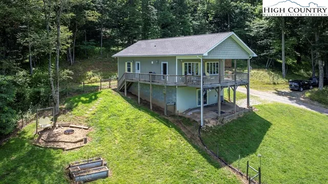 a backyard of a house with table and chairs under an umbrella