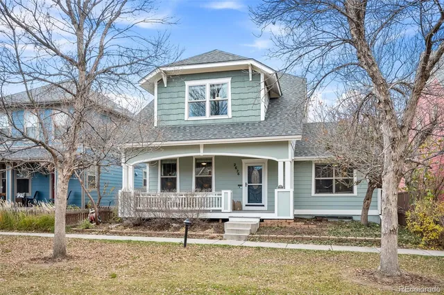 a front view of a house with garden and trees