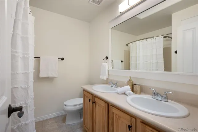a bathroom with a granite countertop sink a toilet and a mirror