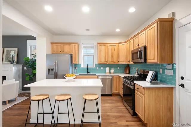 a kitchen with stainless steel appliances granite countertop a kitchen island hardwood floor sink stove and granite counter top