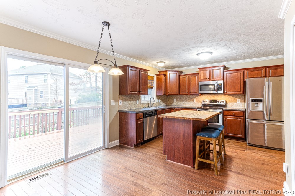 44 Ambrose Point Cameron, NC 28326 - Photo 12 of 48 a kitchen with stainless steel appliances granite countertop a refrigerator a sink dishwasher a stove and a dining table with wooden floor