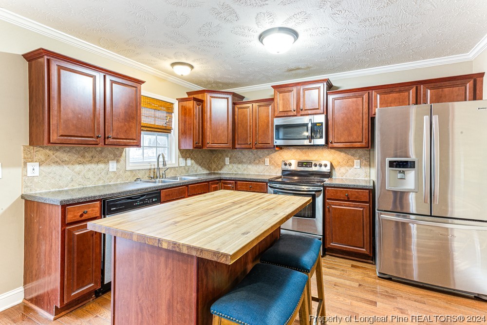 44 Ambrose Point Cameron, NC 28326 - Photo 15 of 48 a kitchen with granite countertop wooden cabinets a refrigerator and a stove top oven