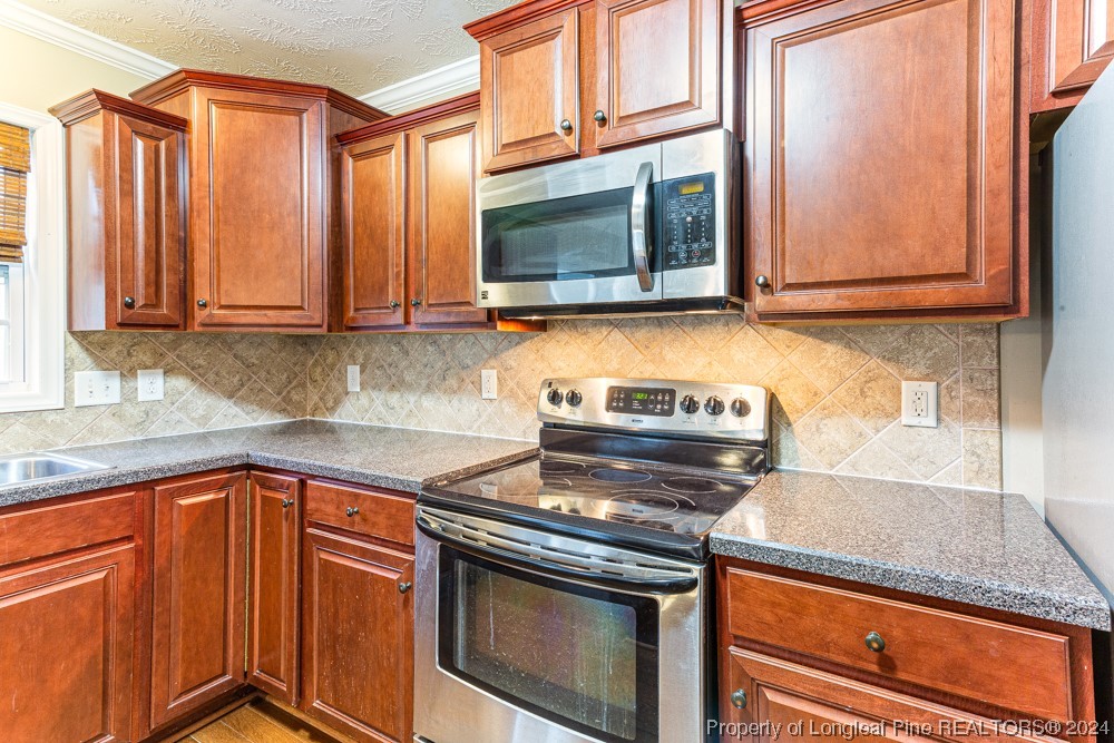 44 Ambrose Point Cameron, NC 28326 - Photo 16 of 48 a kitchen with stainless steel appliances granite countertop a stove a sink and a microwave