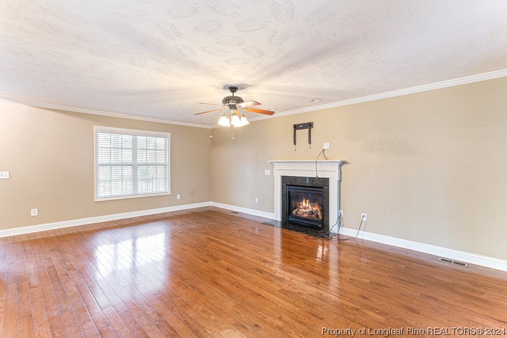 44 Ambrose Point Cameron, NC 28326 - Photo 9 of 48 a view of an empty room with wooden floor fireplace and a window