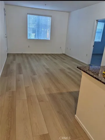a view of a room with wooden floor and a window