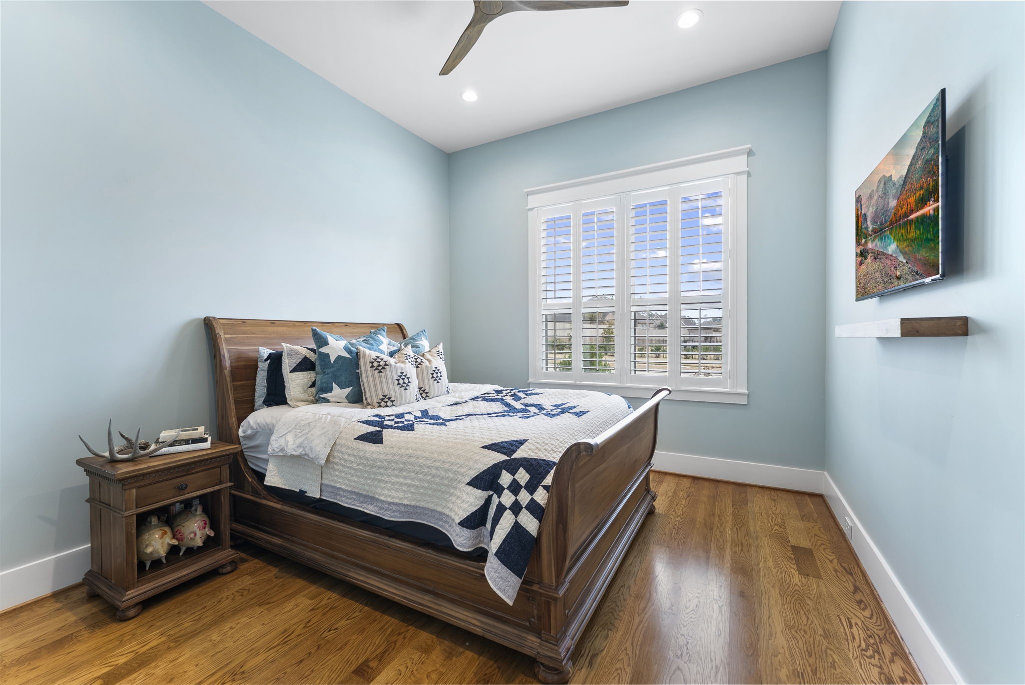14019 Beartooth Bend Trail Conroe, TX 77384 - Photo 19 of 28 Inviting secondary bedroom featuring hardwood floors, natural light, and plantation shutters for added privacy.