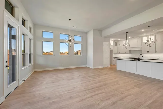 a view of an empty room with wooden floor fireplace and a ceiling fan