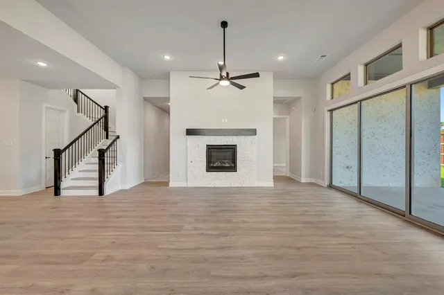 a view of an empty room with window and wooden floor