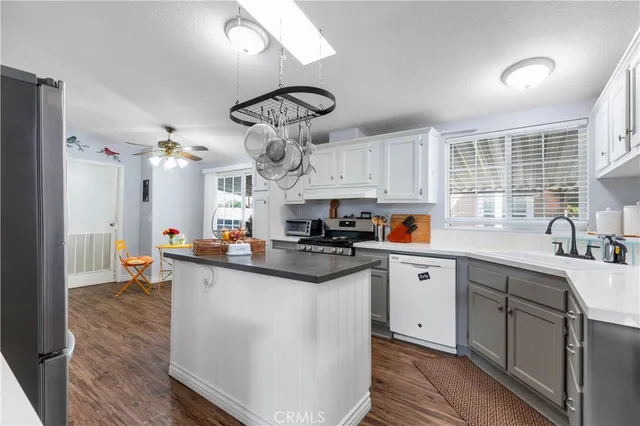 a kitchen with stainless steel appliances a center island wooden floor and cabinets