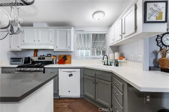 a kitchen with cabinets appliances a sink and a counter top space