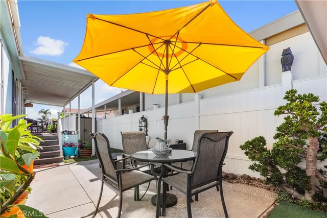 a view of a patio with table and chairs under an umbrella