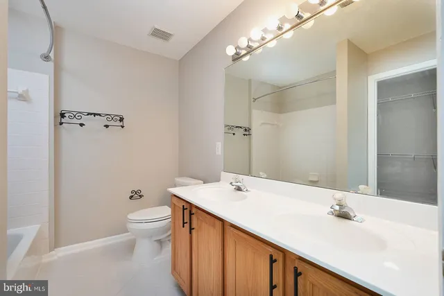 a bathroom with a double vanity sink toilet and shower