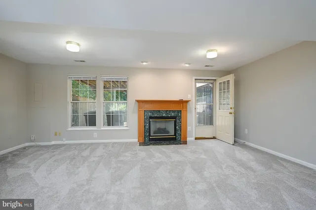 an empty room with a fireplace and window