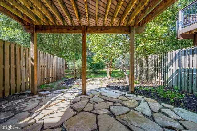 a view of a backyard with table and chairs and wooden fence