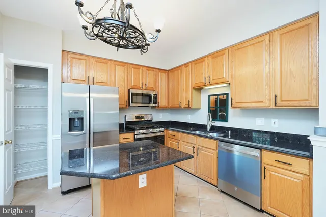 a kitchen with stainless steel appliances granite countertop a sink a stove cabinets and a counter top space
