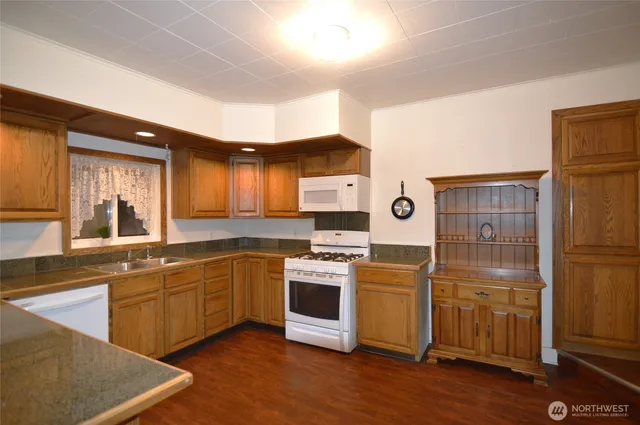a bedroom with a bed table chair and a potted plant