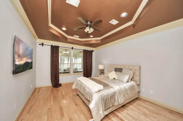 a spacious bedroom with a bed and a flat screen tv