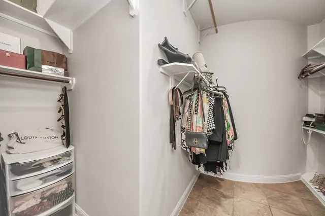 a view of walk in closet with clothes and shoes