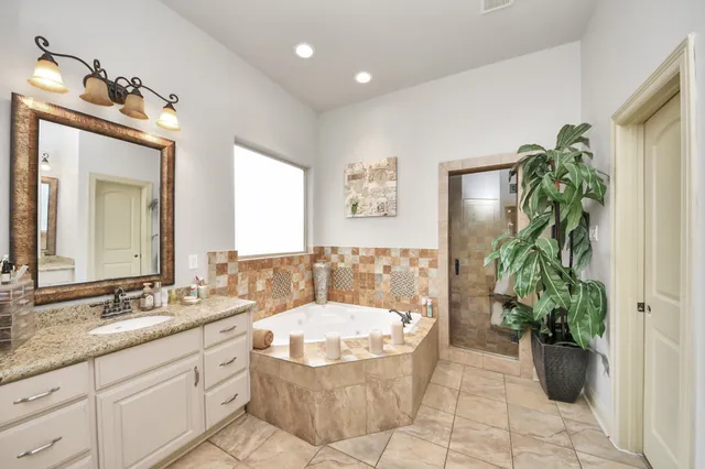 a bathroom with a tub sink and mirror