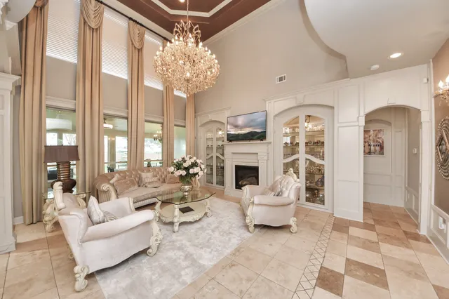 a living room with furniture a chandelier and a fireplace