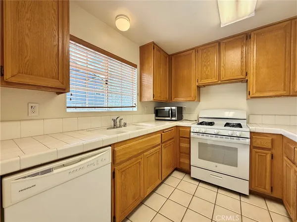 a kitchen with granite countertop white cabinets and white appliances