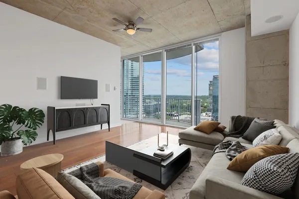 a living room with furniture a flat screen tv and a large window