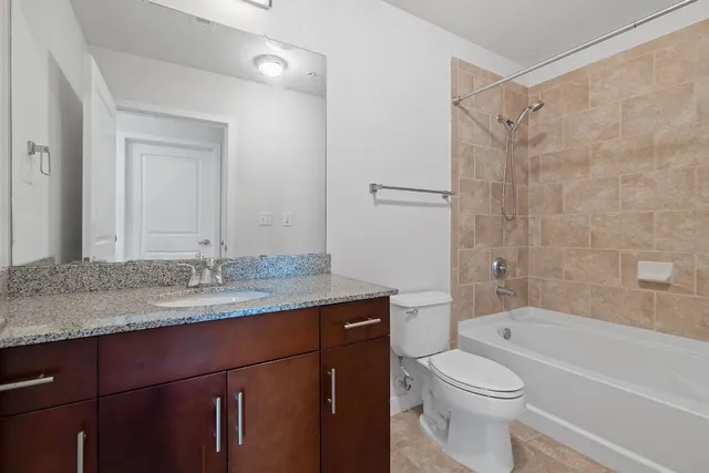 a bathroom with a granite countertop sink toilet and shower