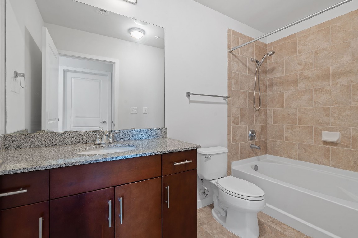 360 Nueces Street, Unit 1518 Austin, TX 78701 - Photo 17 of 35 a bathroom with a granite countertop sink toilet and shower