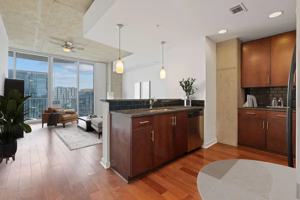 a living room with furniture a flat screen tv and a floor to ceiling window