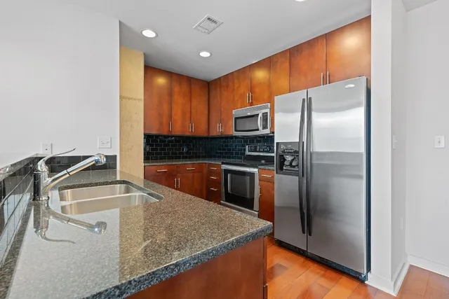 a kitchen with kitchen island a counter top space cabinets and stainless steel appliances