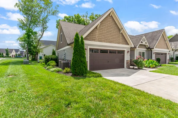 front view of a house and a yard and trees