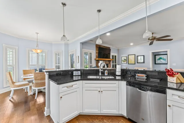 a kitchen with granite countertop a sink and white cabinets