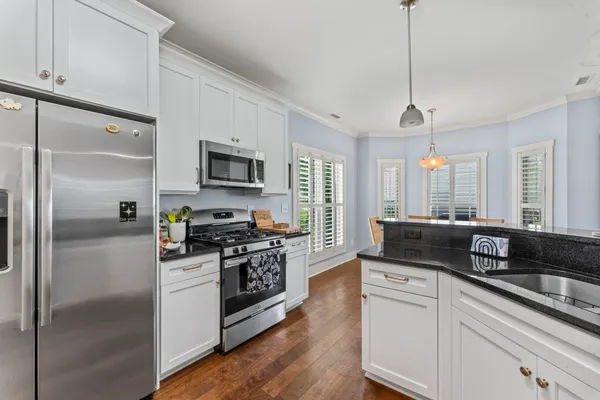 a kitchen with stainless steel appliances granite countertop a refrigerator a stove a sink and a refrigerator