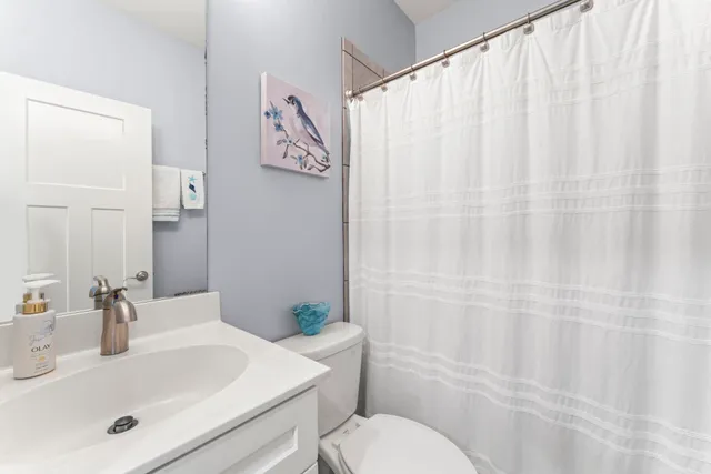 a bedroom with a large bed and a chandelier next to a window