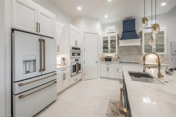 a kitchen with kitchen island granite countertop a sink a counter top space appliances and cabinets