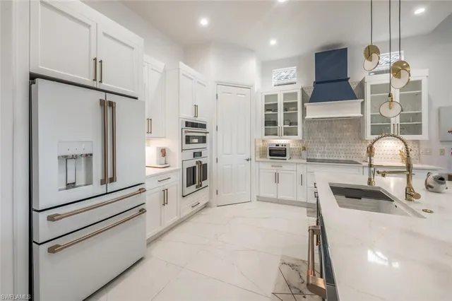 a kitchen with kitchen island granite countertop a sink a counter top space appliances and cabinets