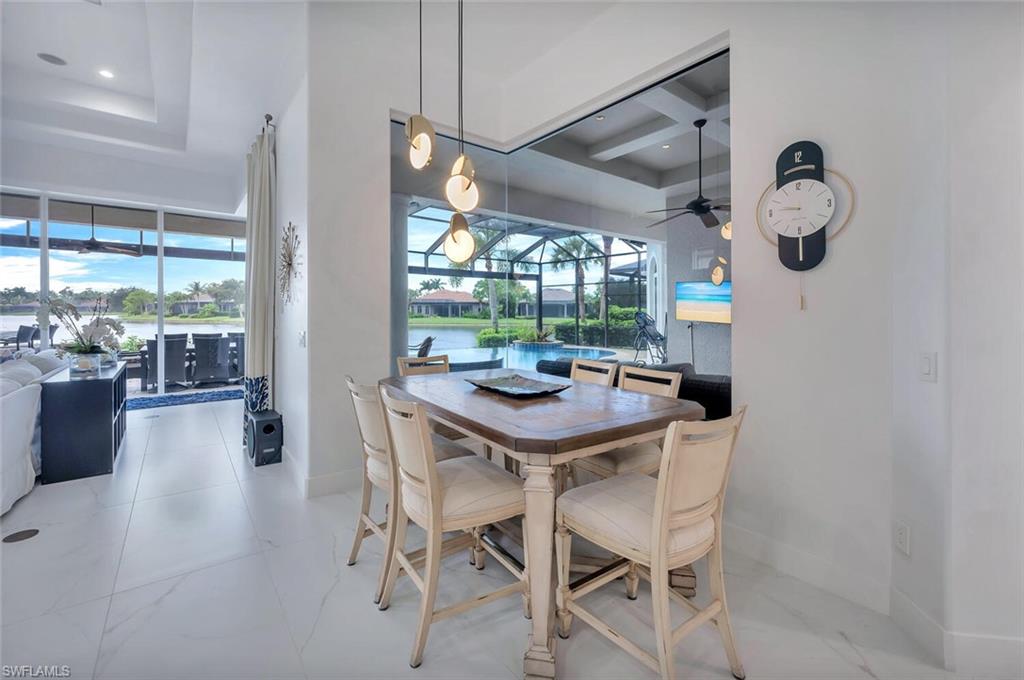8957 Shenendoah Circle Naples, FL 34113 - Photo 20 of 50 a view of a dining room and livingroom with furniture wooden floor a chandelier