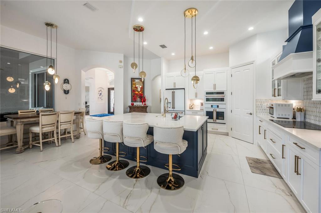 8957 Shenendoah Circle Naples, FL 34113 - Photo 21 of 50 a large kitchen with a table and chairs
