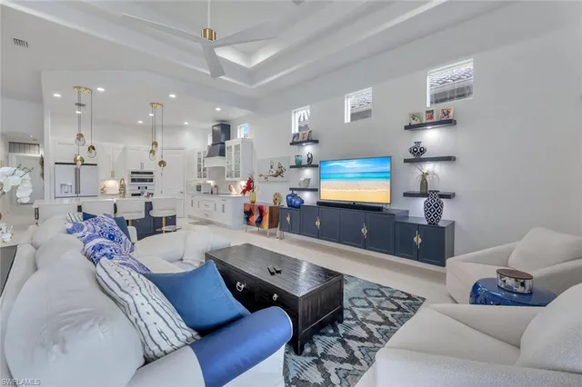 a living room with furniture kitchen view and a chandelier
