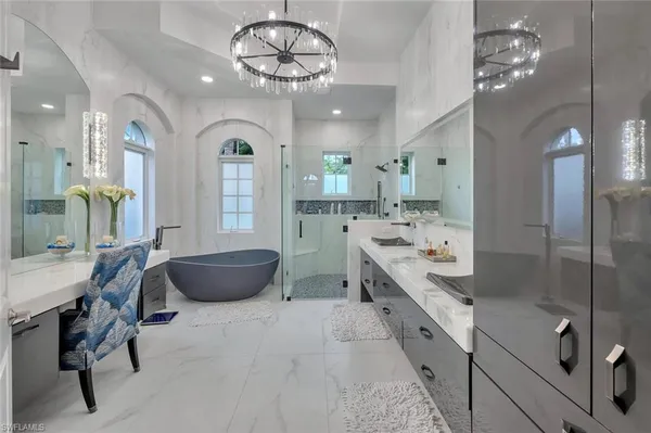a large bathroom with a granite countertop sink a large mirror and a bathtub